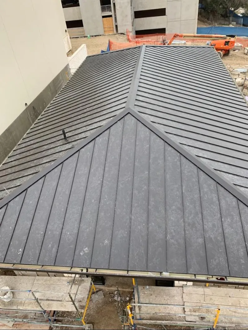 Commercial metal roof construction with crane equipment in Veneta