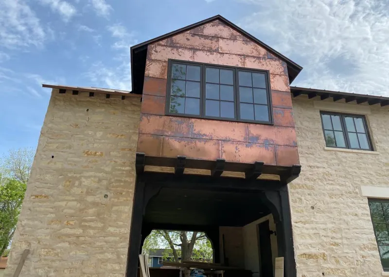 Copper metal panel facade on a stone building for Roof Repair in Veneta